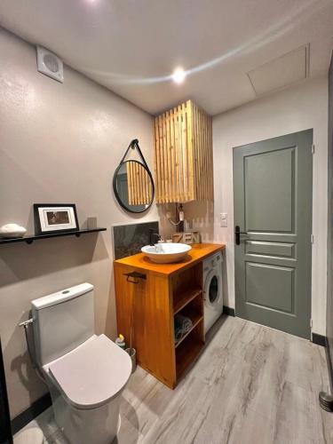 a bathroom with a toilet and a sink and a door at AimerAude in Saint-Pierre