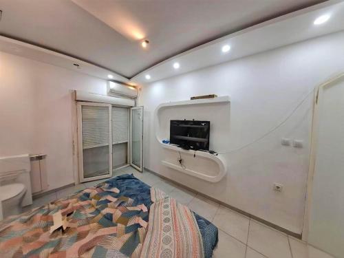 a bedroom with a bed and a tv on the wall at Apartment rental for vacations in Boumerdes