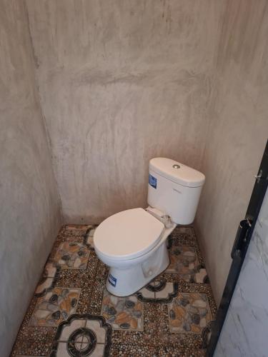 a small bathroom with a toilet in a room at Batu Mela Cottage in Banggai