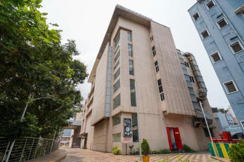 a building on a street with two tall buildings at Open Hotel by Olive - Ambicas Grand in Visakhapatnam
