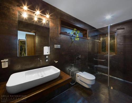 a bathroom with a sink and a toilet and a mirror at 47 - Your Ultimate Relaxation in Colombo in Pannipitiya
