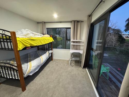 a bedroom with a bunk bed and a balcony at Duo Duo in Auckland