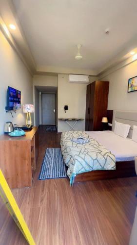 a bedroom with a bed and a wooden floor at Skycabinomaxe in Greater Noida