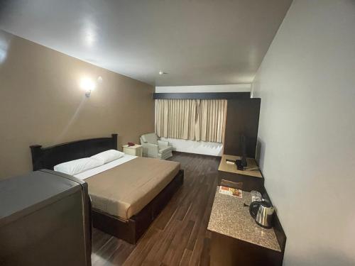 a small hotel room with a bed and a chair at City Residence Rama 6 in Bangkok