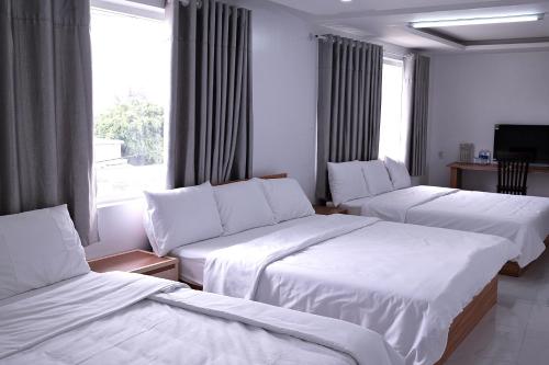 a hotel room with two beds and a window at Khách sạn Lumea in Cam Ranh