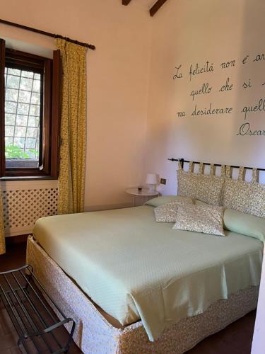 a bedroom with a bed with a quote on the wall at Agriturismo Podere Sant' Antonio in Alberese