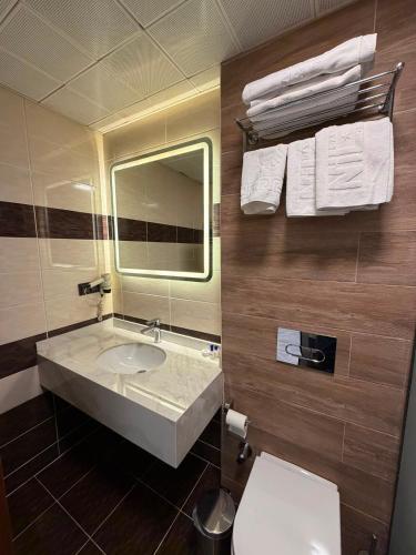 a bathroom with a sink and a mirror and a toilet at Nil Hotel in Gaziantep