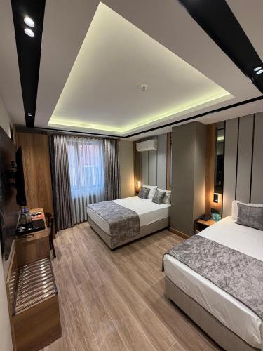 a hotel room with two beds and a television at Nil Hotel in Gaziantep