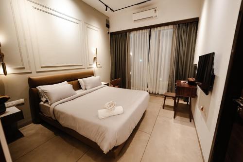 a hotel room with a bed with a towel on it at Woods Luxury Villas in Lonavala