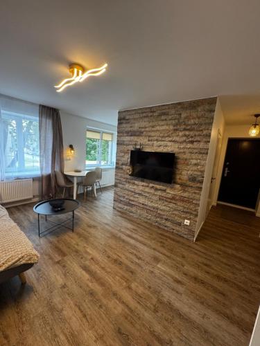 a living room with a brick wall with a fireplace at Amstel LUX in Narva