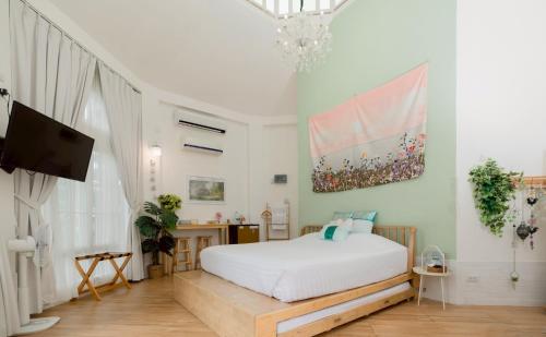 a bedroom with a white bed and a tv at Prim's Cottage Khaokho พริม คอทเทจ เขาค้อ วัดผาซ่อนแก้ว in Khao Kho