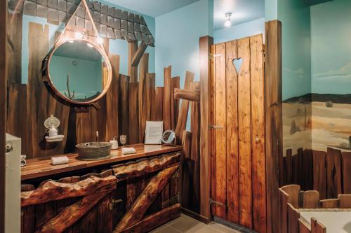 a bathroom with a mirror and a wooden wall at Guest house Western-city in Chaudfontaine