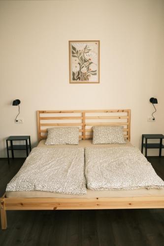 a wooden bed in a bedroom with two lamps at Chata Horalka in Jáchymov