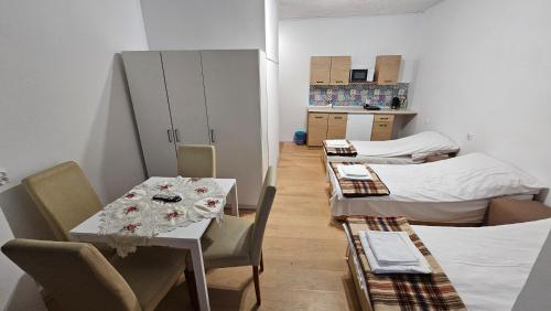 a room with two beds and a table and chairs at Keja II in Łeba