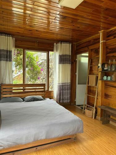 a bedroom with a large bed and a wooden ceiling at Nhà Để Chill Homestay in Da Lat