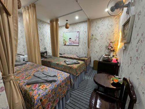 a hotel room with two beds and a table at Van Hoa Boutique Hotel in Hanoi