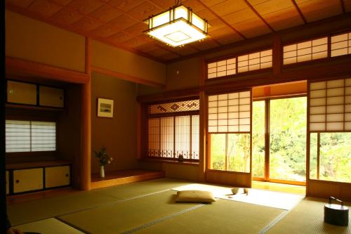 a room with a large room with windows and a rug at 縁の宿 北堀 in Matsue