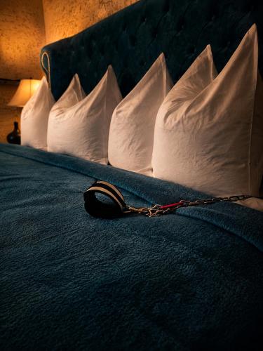 a chain on a bed with white pillows at Zámoček Mraznica in Prievidza