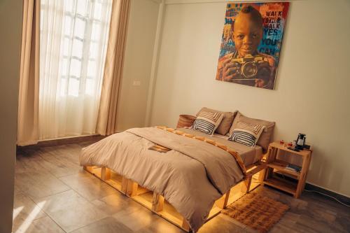 a bedroom with a bed and a painting on the wall at Lights & Kulture Homes in Arusha