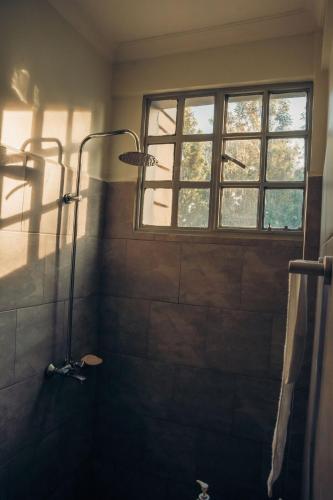 a bathroom with a shower with a window at Lights & Kulture Homes in Arusha