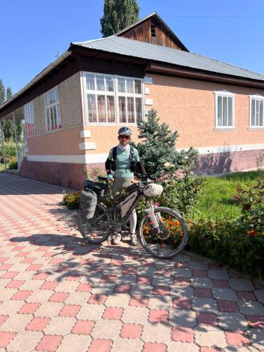 a person standing next to a bike in front of a building at Fazenda guest house in Oktyabrʼskoye