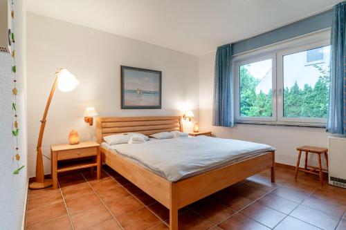 a bedroom with a bed and a window at Romantica EG in Sankt Peter-Ording