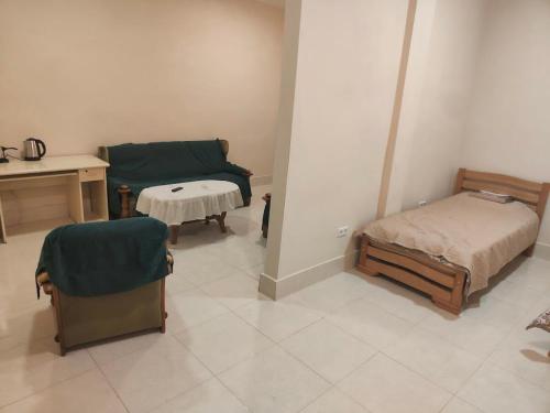 a room with two beds and a desk and a table at Hotel RELAX TIME in Lanch'khut'i