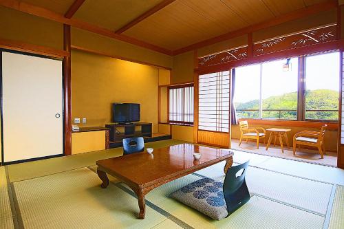 a living room with a coffee table and a tv at Ooedo Onsen Monogatari Awara in Awara