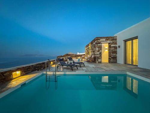 a villa with a swimming pool at night at Villa Plora, by Estia in Áno Meriá