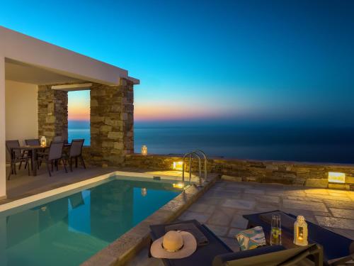 a villa with a swimming pool at night at Villa Plora, by Estia in Áno Meriá