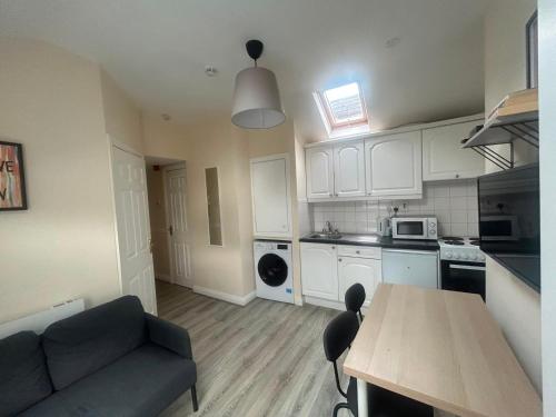 a kitchen with a couch and a table in a room at Charming 1Bed Flat In Dublin Sleeps 2 in Dublin