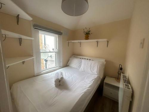a small bedroom with a white bed with a window at Charming 1Bed Flat In Dublin Sleeps 2 in Dublin