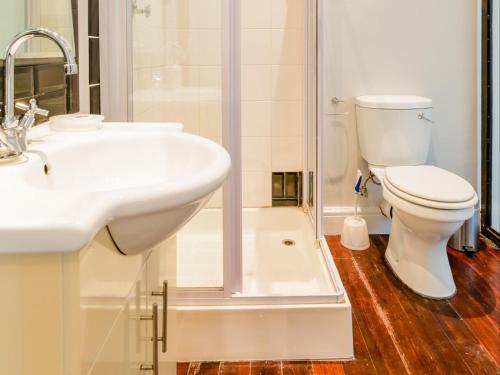 a bathroom with a toilet and a sink and a shower at Boschhuis Apartments - Stellenbosch in Stellenbosch