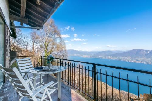 a table and chairs on a balcony with a view of the water at Lago Azzurro Villa: Infinity Lake View - Happy Rentals in Premeno