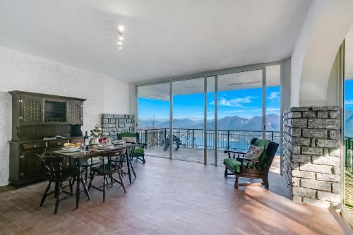 a kitchen and dining room with a table and chairs at Lago Azzurro Villa: Infinity Lake View - Happy Rentals in Premeno