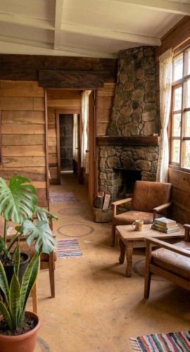 a living room with a stone fireplace and a table at Paxel Forest in San Lorenzo El Cubo