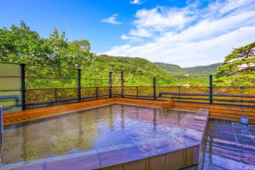 a swimming pool on a balcony with mountains in the background at TAOYA Nasu Shiobara in Nasushiobara