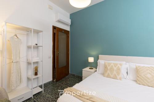 a bedroom with a white bed and a dress rack at Central Cagliari by Propertize in Cagliari