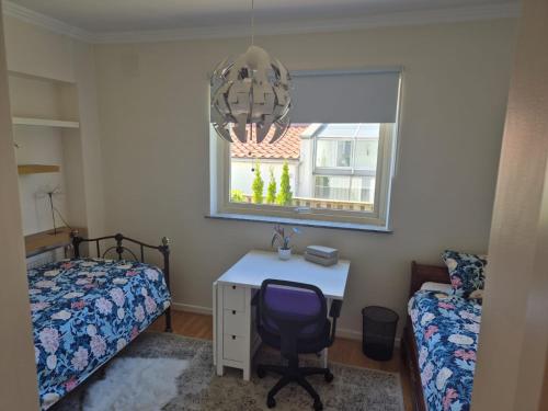 a bedroom with a desk and a bed and a window at Charmig bottenvåning i Limhamn in Limhamn