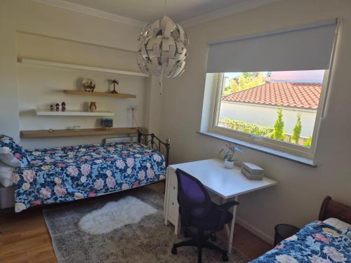 a bedroom with a bed and a desk and a window at Charmig bottenvåning i Limhamn in Limhamn