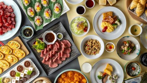 a table topped with plates of food and bowls of food at Madarao Kogen Hotel in Iiyama