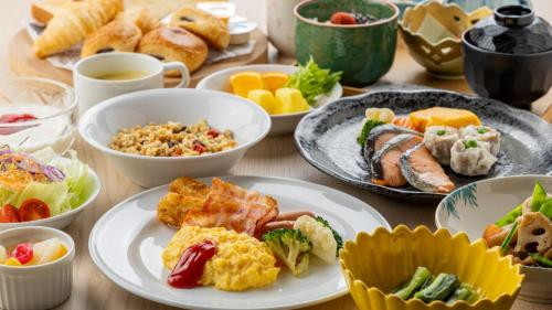 a table topped with plates of food and bowls of food at Madarao Kogen Hotel in Iiyama