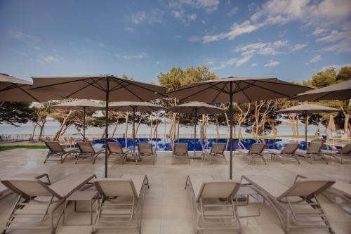 a row of tables and chairs with umbrellas at Villa Arausa in Vodice