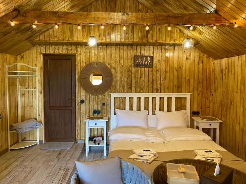 ein Schlafzimmer mit einem großen Bett in einer Holzwand in der Unterkunft Tesaran Stepanavan Guest House, Apart Hotel in Stepanawan
