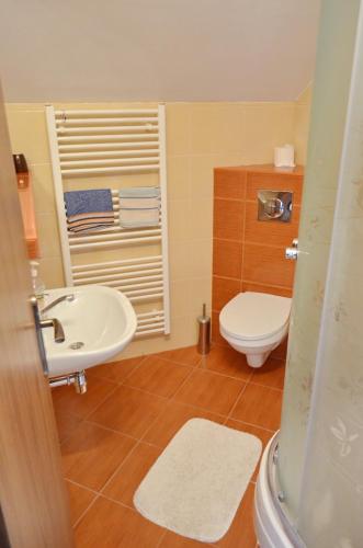 a bathroom with a white toilet and a sink at Penzion Mirabel in Bešeňová