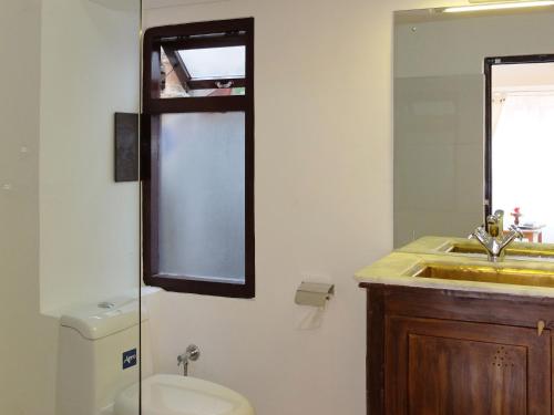 a bathroom with a toilet and a sink and a mirror at Lalit Heritage Home in Pātan