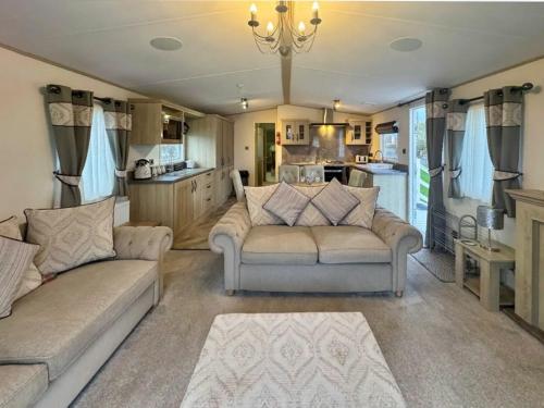a living room with two couches and a kitchen at Abi Beaumont - Ty Mawr in Rowen