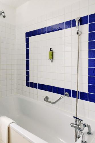 a bath tub with blue and white tiles at Thalacap Camargue in Saintes-Maries-de-la-Mer