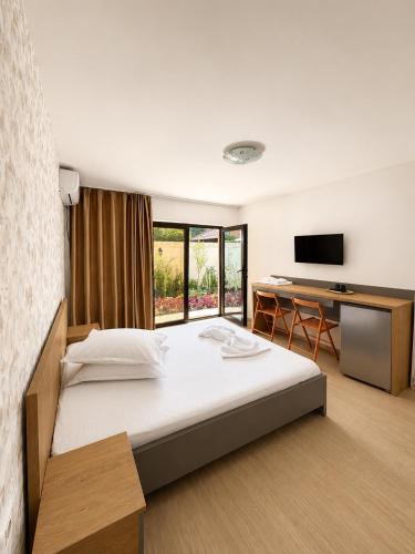 a bedroom with a bed and a desk and a television at Casa Maxim Eforie Nord in Eforie Nord