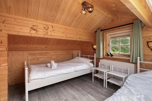 a bedroom in a log cabin with two beds at Luxe, rust en ruimte bij de Veluwse Vogels in Epe in Epe